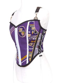 Our EXCLUSIVE limited edition Sport Team Corsets Collection. Made exclusively to order in house, Va, USA. Show off your pride with our Sports Team Corset! Put on the game day colors of your favorite team and get noticed in this shapewear corset designed to get attention. HOW TO WEAR Wear this corset on a naked body, over a cozy sweater or a stylish cotton shirt to achieve various fashion-forward ensembles. Its adjustable size and versatile styling options make it an ideal choice for any occasion Ravens Football Game Outfit, Black Urban Corset, Black And Purple Corset, Ravens Outfit Baltimore, Soccer Jewelry, Ravens Jersey, Sports Team Apparel, Baltimore Ravens Football, Corset Shapewear