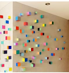 multicolored paper squares are hanging on the wall