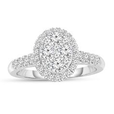 a white gold ring with diamonds on the band and an oval shaped center stone in the middle