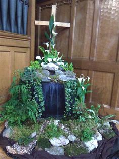 there is a small waterfall made out of rocks and plants