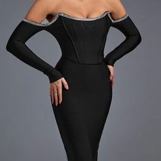 a woman wearing a black evening gown with silver trimmings and off the shoulder sleeves