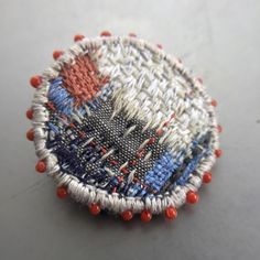 a close up of a small piece of cloth with red, white and blue beads