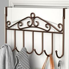 a coat rack with two coats hanging from it's sides and a purse next to it