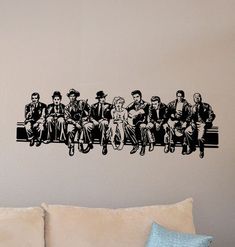 a group of people sitting on top of a couch next to a wall decal