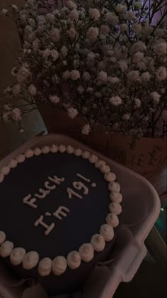 a birthday cake sitting on top of a table next to a vase filled with flowers