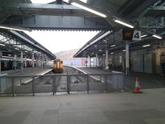 an empty train station with a train on the tracks