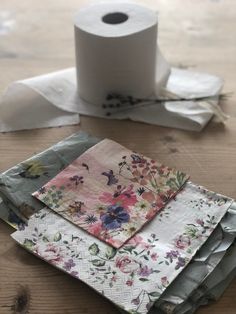 several napkins are stacked on top of each other next to a roll of toilet paper