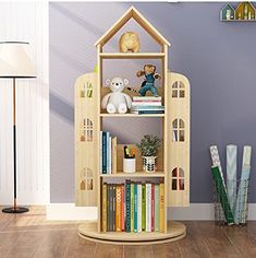 a book shelf with books and stuffed animals on it next to a purple wall in a child's room