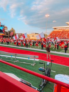 the football team is on the field with red and white flags in front of them