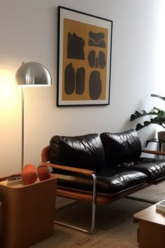 a black leather couch sitting in a living room next to a lamp