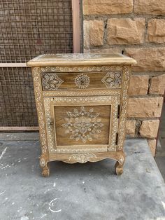 an old wooden cabinet sitting in front of a brick wall