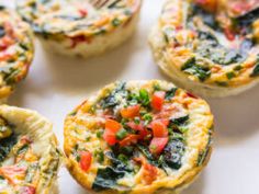 mini quiches filled with vegetables and cheese on a white plate, ready to be eaten