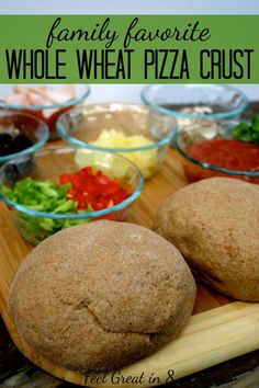 family favorite whole wheat pizza crust is on a cutting board with bowls of vegetables and sauces