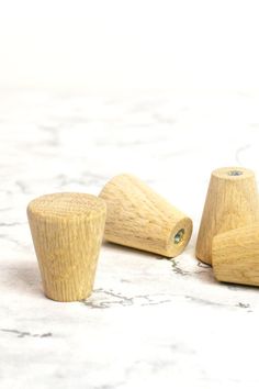 three wooden stoppers sitting on top of a marble countertop next to each other