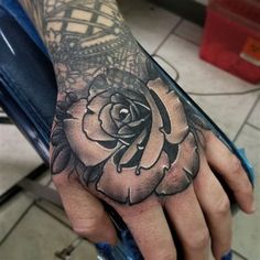 a person's hand with a tattoo on it and a rose in the middle