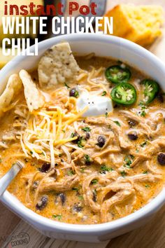 a bowl of instant pot white chicken chili with tortilla chips and sour cream