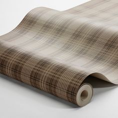 a brown and tan plaid wallpaper on a white surface with a roll of tape