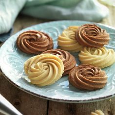 some cookies are sitting on a plate with chocolate frosting in the shape of spirals