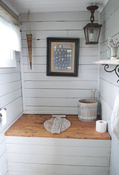 a bathroom with a wooden counter and white walls, along with a framed photograph on the wall