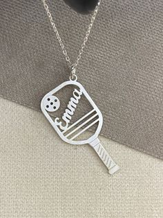 a silver necklace with a cooking utensil on it