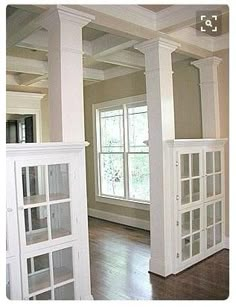 an empty living room with wood floors and white columns