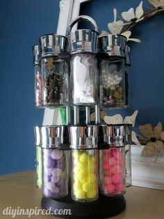 a stack of jars filled with candy sitting on top of a table next to a mirror