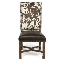 a brown and white cow print upholstered chair with leather seat pad on the back