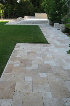 an outdoor patio with grass and stone pavers