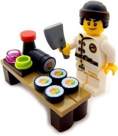 a lego man is cooking sushi on a table