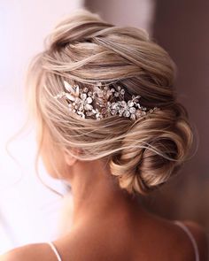 a woman wearing a wedding hair comb with flowers on it's head and blonde hair