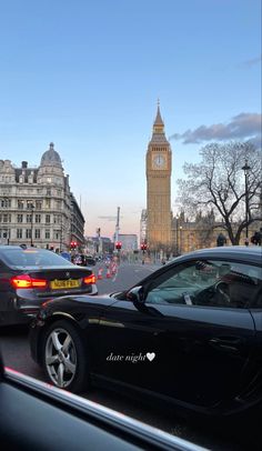 cars driving down the street in front of big ben