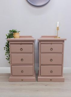 two pink dressers sitting next to each other in front of a wall with a clock on it