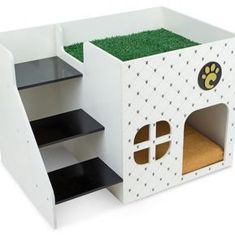 a dog house made out of cardboard with grass inside