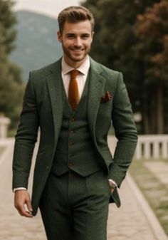 a man in a green suit and tie standing on a brick walkway with his hands in his pockets