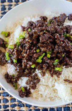 an easy korean ground beef recipe on top of rice in a white bowl with green onions