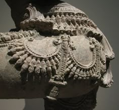 a close up of an ancient statue with intricate designs on it's back end