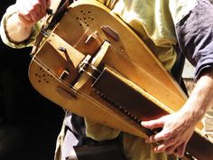 a man holding a large wooden instrument in his hands