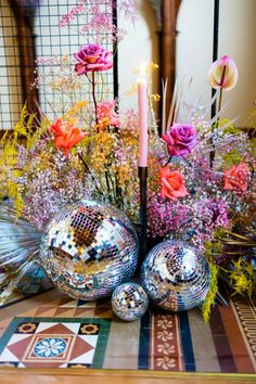 a table topped with disco balls and flowers