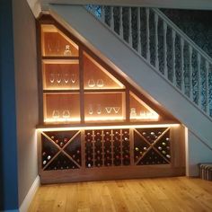 a wine cellar under the stairs in a house