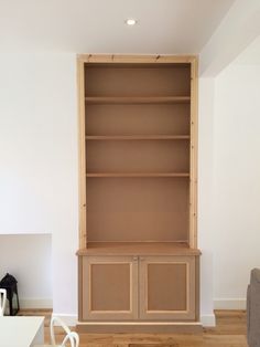 an empty living room with white walls and wooden shelves