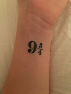 a woman's wrist tattoo with the number nine in black ink on her left arm