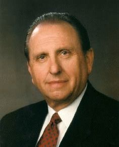 a man in a suit and tie posing for a photo with his head turned to the side