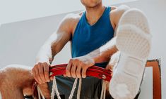 a man sitting on top of a chair with his leg in the air and wearing white socks