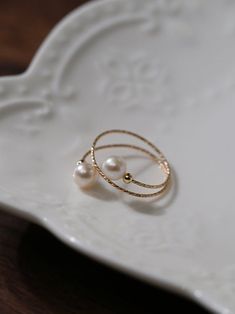 Experience the timeless charm of our 14K Gold-Filled Freshwater Double Pearl Wrapped Wire Ring Elevate any ensemble with its luxurious touch, modern design, adjustable fit, and versatile styling. Make a statement of elegance and sophistication wherever you go. Metal: 14K Gold Filled Gemstone: Freshwater Pearls Pearl Diameter: 5.5-6mm Size: Adjustable 6-8 Weight: 1g