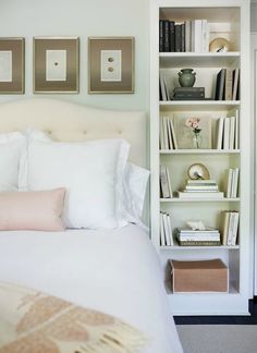 a bed with white sheets and pillows in a bedroom next to a book shelf filled with books