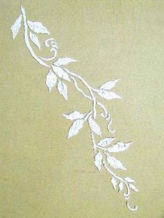 a white stencil on the side of a wall that has leaves and vines painted on it