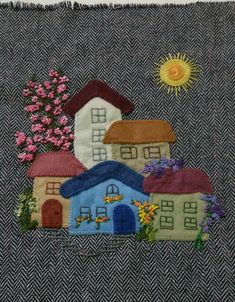 a close up of a piece of cloth with houses on it and flowers in the background