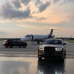 two cars are parked in front of an airplane