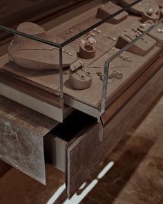 a wooden table with drawers and jewelry on it's sides in a display case