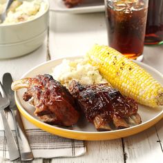 barbecued ribs, corn on the cob and mashed potatoes are served on a plate